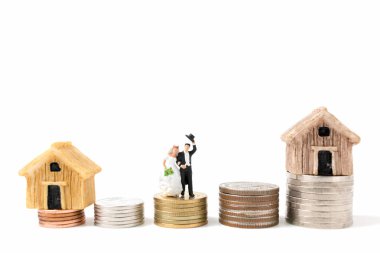 Minyatür insanlar üzerinde düğün beyaz arka plan üzerinde sikke yığını.