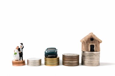 Minyatür insanlar üzerinde düğün beyaz arka plan üzerinde sikke yığını.