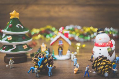 Noel dekorasyonları ahşap bir arka plan üzerinde oluşturma minyatür insanlarla yaratıcı kavramı. 