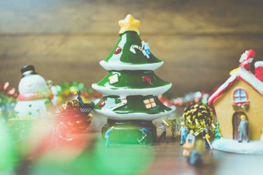 Noel dekorasyonları ahşap bir arka plan üzerinde oluşturma minyatür insanlarla yaratıcı kavramı. 