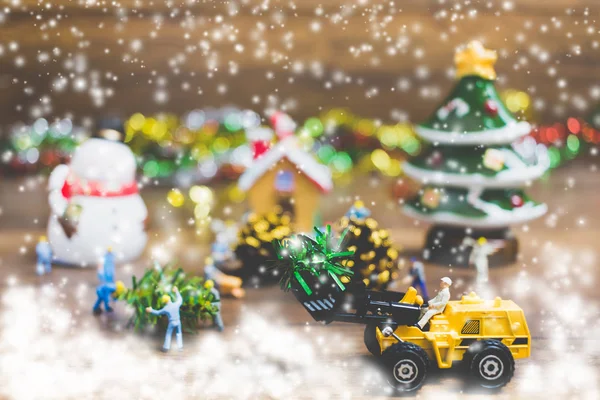 Kreatives Konzept mit Miniaturmenschen, die Weihnachtsdekorationen auf einem hölzernen Hintergrund schaffen. — Stockfoto
