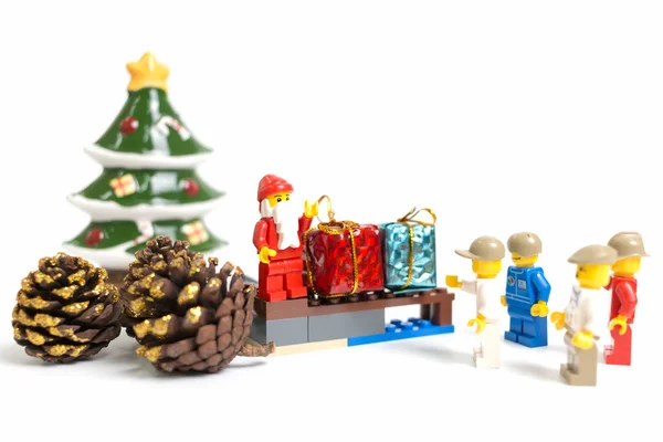 Минифигурка Лего Санта Клауса с рождественской сценой на белом фоне — стоковое фото