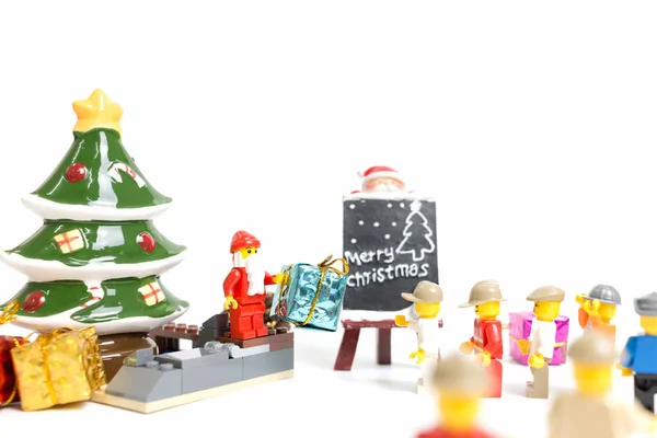 Минифигурка Лего Санта Клауса с рождественской сценой на белом фоне — стоковое фото