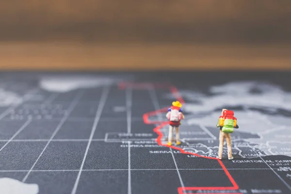 Personnes miniatures routard marchant sur la carte du monde — Photo
