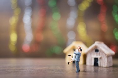 Minyatür çift ahşap zemin üzerinde sarılma 