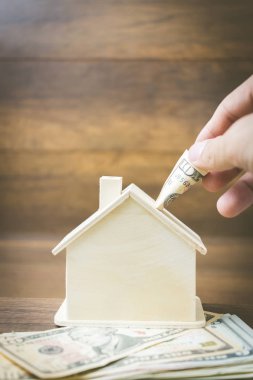 Ahşap arka plan üzerinde para ve ev modeli , 