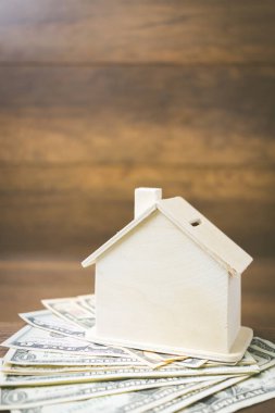 Ahşap arka plan üzerinde para ve ev modeli , 