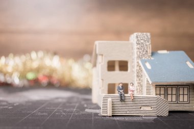 Sikke para ile ev ile oturan minyatür insanlar. 