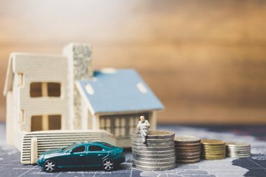 Sikke para ile ev ile oturan minyatür insanlar. 