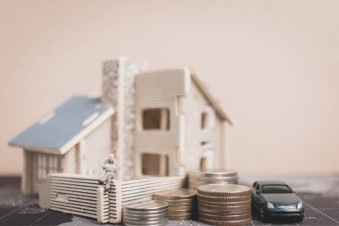 Sikke para ile ev ile oturan minyatür insanlar. 