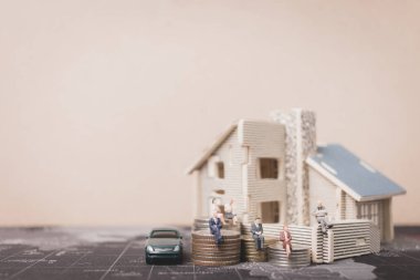 Sikke para ile ev ile oturan minyatür insanlar. 