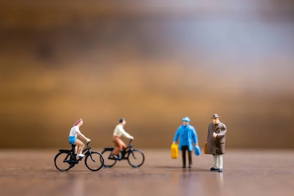 Personas en miniatura viajeros de pie sobre fondo de madera — Foto de Stock