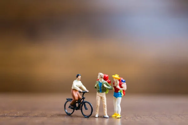 Miniaturmenschen Reisende stehen auf hölzernen Hintergrund — Stockfoto