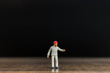 Minyatür insanlar çalışan siyah arka plan ile ahşap zemin üzerinde 