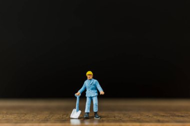 Minyatür insanlar çalışan siyah arka plan ile ahşap zemin üzerinde 