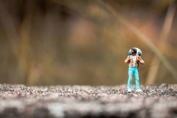 Mochilero miniatura de pie en la pared de hormigón — Foto de Stock