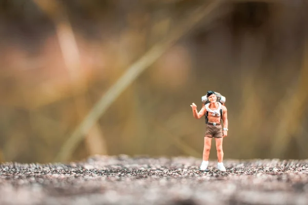 Mochilero miniatura de pie en la pared de hormigón — Foto de Stock