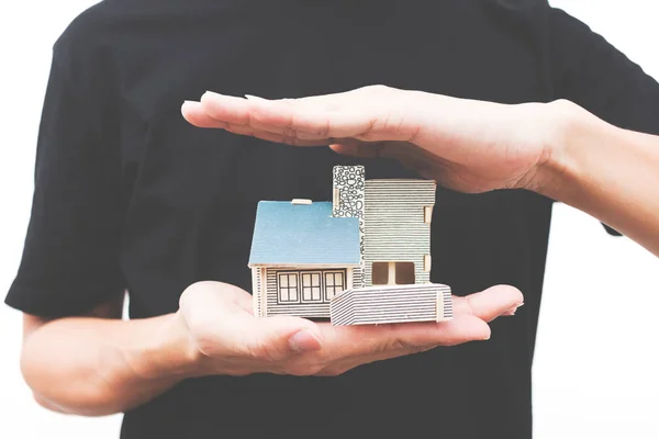 Bir ev modeli ayrı tut moduyla beyaz arka plan üzerinde tutan adam el 