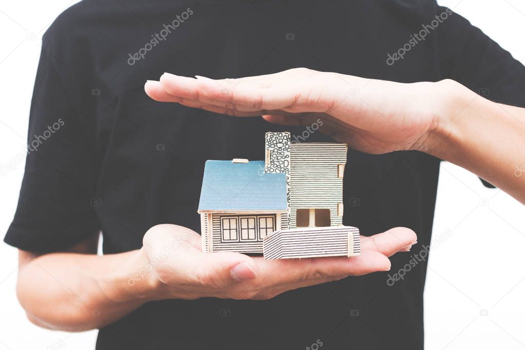 Man hand holding a  home model on isolate white background 