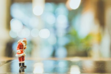 Minyatür insanlar, cam üzerinde Noel Baba duran 