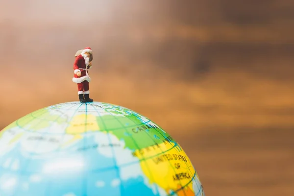 Miniatyr personer: Santa Claus bär på Globen — Stockfoto