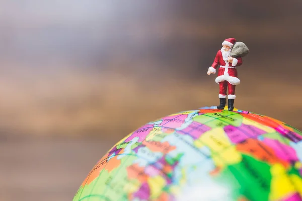 Personas en miniatura: Santa Claus llevando el globo —  Fotos de Stock