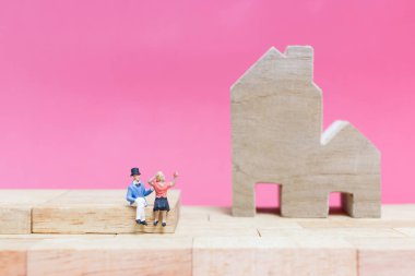 Evi pembe bir arka plan üzerinde çift , 