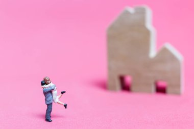 Evi pembe bir arka plan üzerinde çift , 