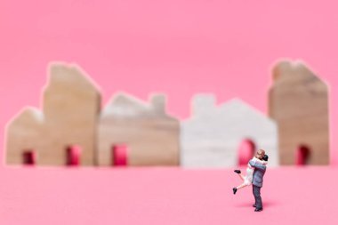 Evi pembe bir arka plan üzerinde çift , 