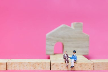 Evi pembe bir arka plan üzerinde çift , 