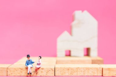 Evi pembe bir arka plan üzerinde çift , 