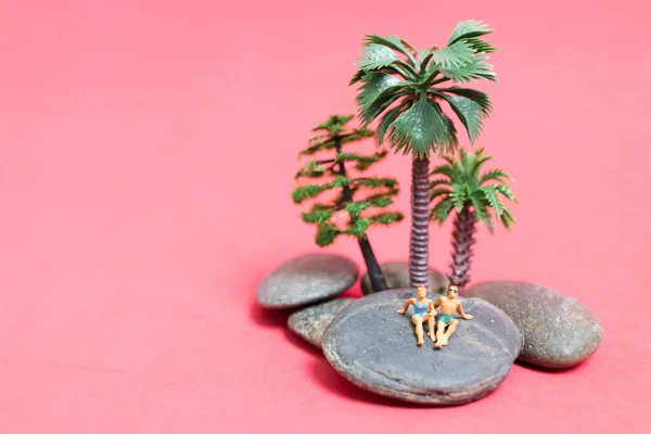 Miniaturmenschen im Badeanzug relaxen auf dem Felsen — Stockfoto