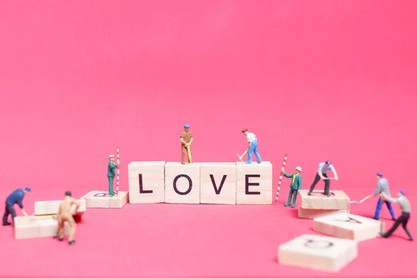 Miniaturmenschen: Working Team Building Wort "Liebe " — Stockfoto