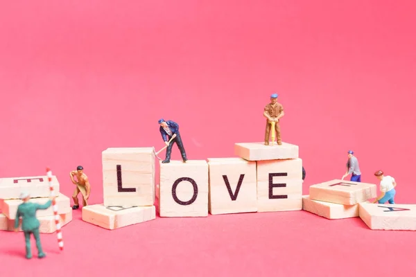 Miniaturmenschen: Working Team Building Wort "Liebe " — Stockfoto
