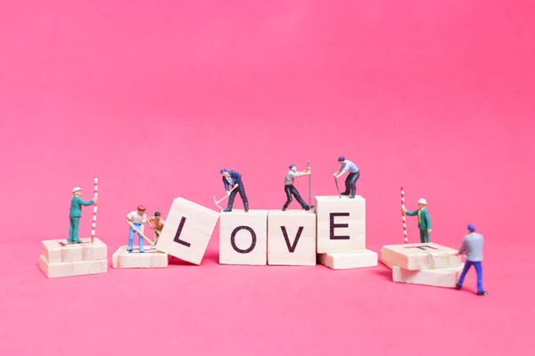 Miniaturmenschen: Working Team Building Wort "Liebe " — Stockfoto