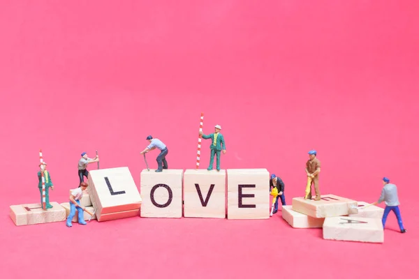 Miniaturmenschen: Working Team Building Wort "Liebe " — Stockfoto