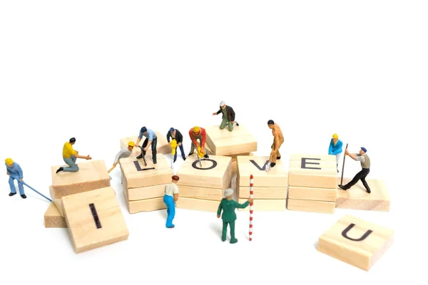 Miniature people: Worker team building word "Love  " — стоковое фото