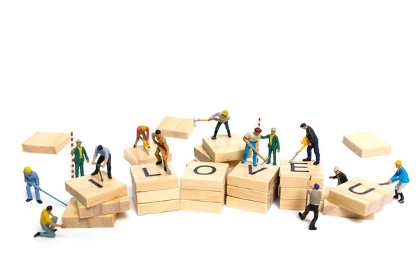 Miniature people: Worker team building word "Love  " — стоковое фото
