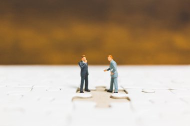 Minyatür insanlar: işadamı jigsaw üzerinde duran 