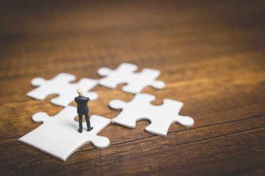 Minyatür insanlar: işadamı jigsaw üzerinde duran 