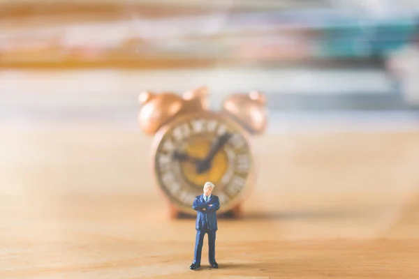 Personas en miniatura: Empresario de pie con reloj antiguo — Foto de Stock