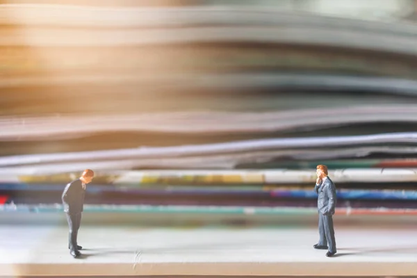 Personas en miniatura: Empresario de pie y pila de libros — Foto de Stock