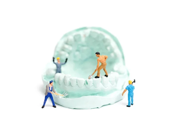 Equipo de trabajadores en miniatura está presentando dientes falsos — Foto de Stock