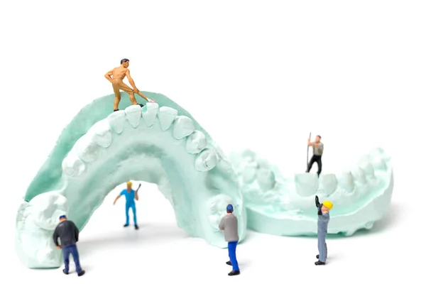 Miniaturarbeiter-Team feilt an falschen Zähnen — Stockfoto