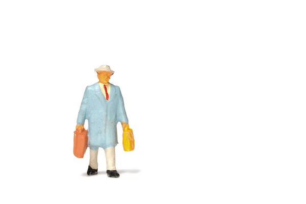 Miniaturní lidí; Cestovatel drží kabelku na bílém poz — Stock fotografie