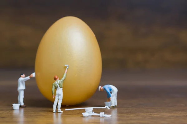 Miniature people :Painter is painting Easter-eggs