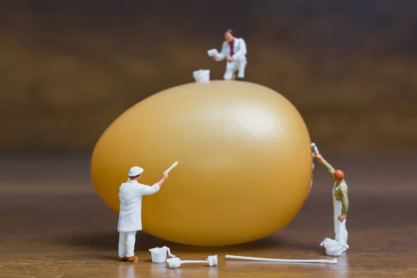 Miniature people :Painter is painting Easter-eggs