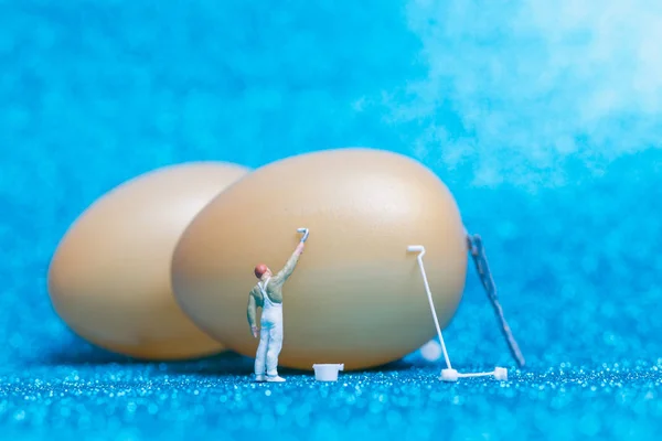 Miniature people :Painter is painting Easter-eggs for Easter day