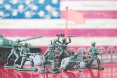 Minyatür oyuncak askerler Amerikan bayrağı arka plan ile savaş sahnesinde