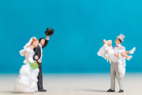 Miniaturmenschen: Braut und Bräutigam auf blauem Hintergrund. — Stockfoto